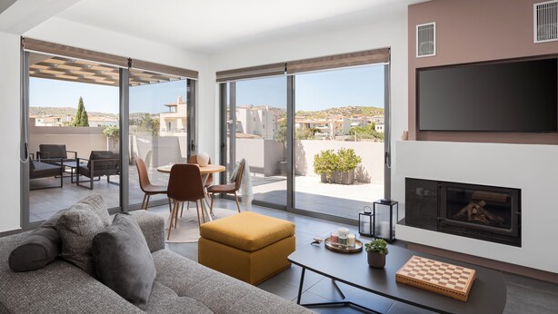 Una sala moderna con sofá, mesa de centro y chimenea.