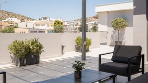Terraza en la azotea con pérgola, mobiliario exterior y plantas en macetas.
