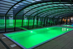 A swimming pool with a glass enclosure and green lighting. - Comfortable holiday homes with SPA Rewal (Rewal)