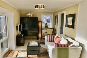 Ein Wohnzimmer mit Sofa, Couchtisch, Kamin und Fenster.