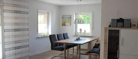 Una cocina moderna con comedor, refrigerador y ventana con vistas.