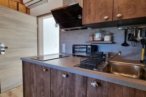 Eine moderne Küche mit Backofen, Kaffeemaschine und einer Spüle aus Edelstahl.