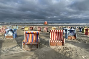 Een strand met tal van kleurrijke strandstoelen en een uitkijktoren voor de badmeester.