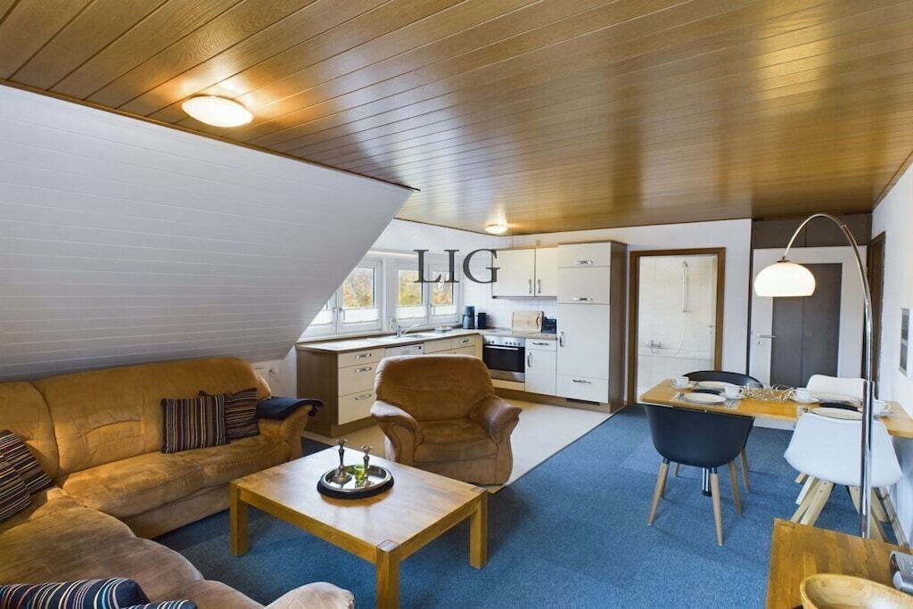 Una sala de estar moderna con sofá, mesa de centro y comedor con sillas y mesa.