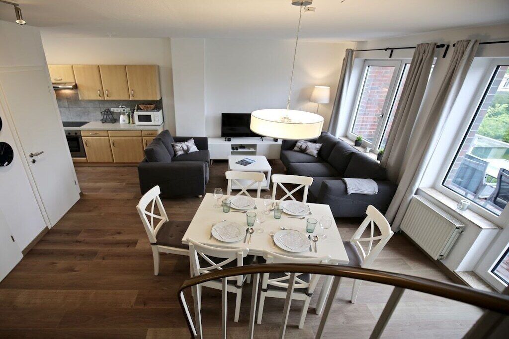A modern apartment with a dining area, a living room, and a kitchen.