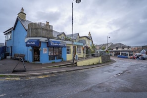 A coastal town with a blue building labeled 'The Cabin' and a yellow building with a sign 'The Tea Garden Cafe'.