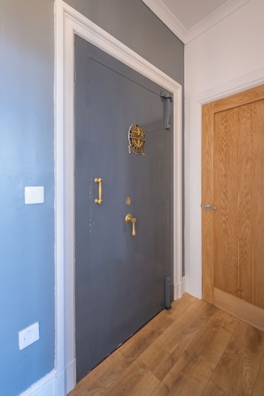 A closed door with a brass handle and a brass doorknob, a brass doorknob lock, and a brass doorknob latch.