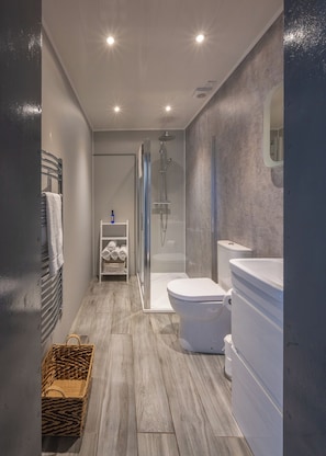 A modern bathroom with a shower, toilet, and sink. - Cosy former converted bank in heart of a busy working fishing village. (Mallaig)