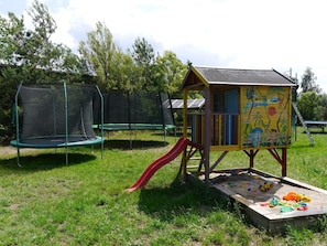 A playground with a slide, a trampoline, and a sand play area. - Apartment with Garden, Terrace, Private Garden & Wi-Fi in Milmersdorf (Milmersdorf)