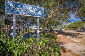 A sign for Romar Village with a rustic wooden structure and a clear sky in the background. - Romar Village 312  Family-Friendly Beach Retreat (Orange Beach)