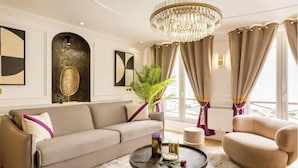 A modern living room with a sofa, armchair, round coffee table, and decorative items. - WHERE HISTORIC GRANDEUR MEETS CONTEMPORARY COMFORT - OPÉRA - MADELEINE (Paris)