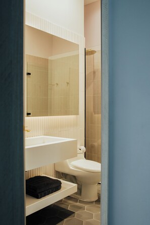 A bathroom with a white sink, a toilet, and a mirror above the sink. - Top Provenza Penthouse 3-bedroom apartment w/ AC, Elevator, Fast Wifi, Parking (Medellín)