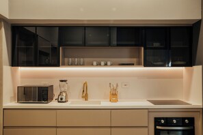 A modern kitchen with a built-in microwave, a coffee maker, and a knife block on the countertop. - Top Provenza Penthouse 3-bedroom apartment w/ AC, Elevator, Fast Wifi, Parking (Medellín)