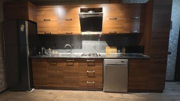 Een moderne keuken met houten kastjes, roestvrijstalen apparatuur en een vaatwasser.