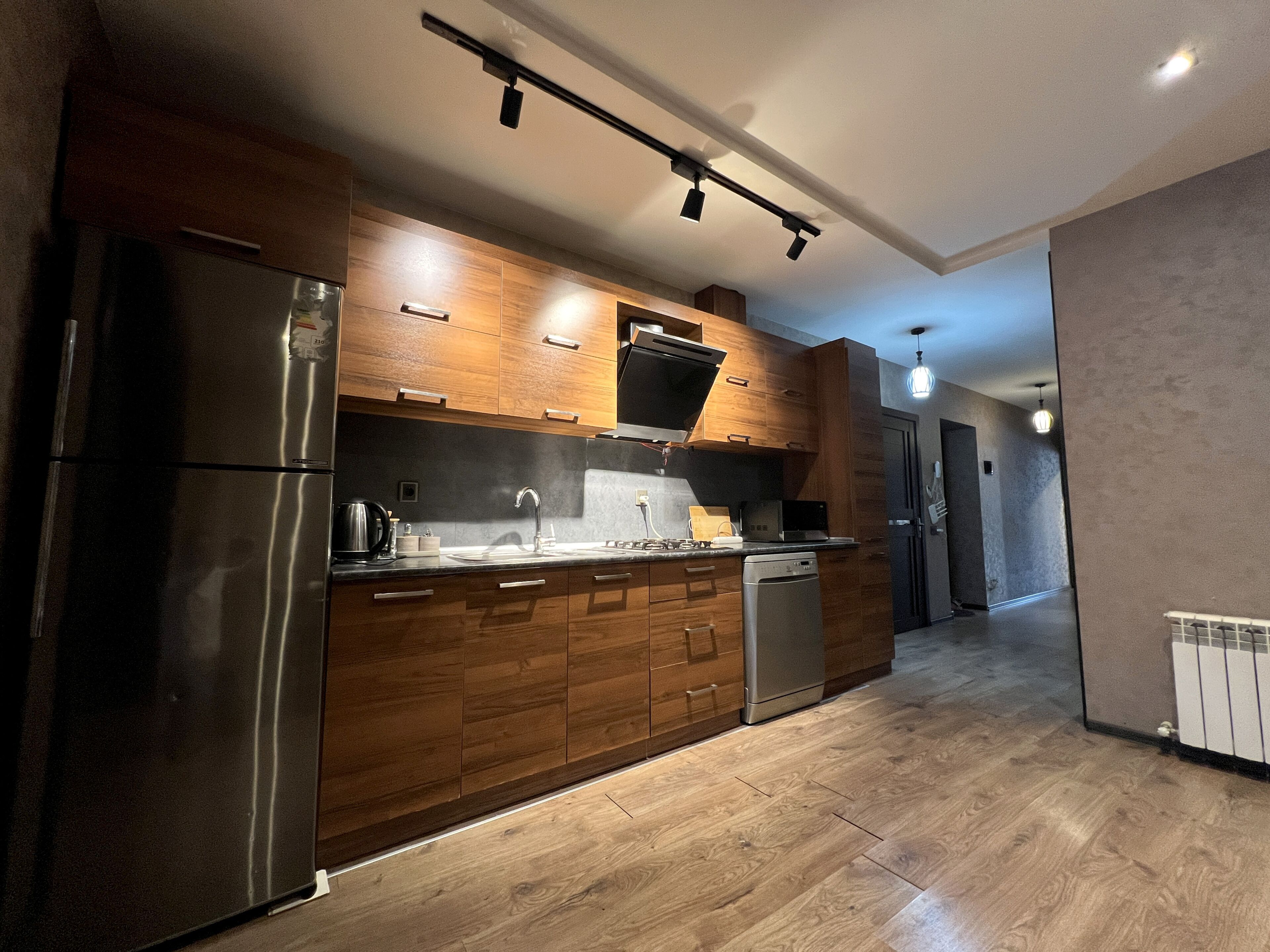 Een moderne keuken met houten kastjes, roestvrijstalen apparatuur en een centraal eiland.