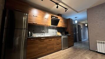 Een moderne keuken met houten kastjes, roestvrijstalen apparatuur en een centraal eiland.