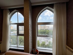 A room with two arched windows, a bed, and a potted plant. - Spacious 2BR near Winter Park - Sleeps 5 (Baku)