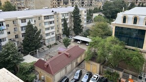 Un edifici residencial de diverses plantes amb balcons, una zona d'aparcament i un edifici amb un estil arquitectònic distintiu.
