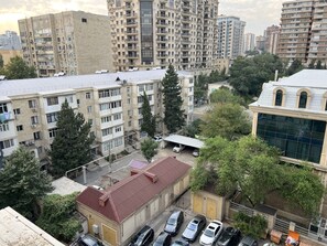 A multi-story residential building with balconies, a parking area, and a building with a distinctive architectural style. - Spacious 2BR near Winter Park - Sleeps 5 (Baku)