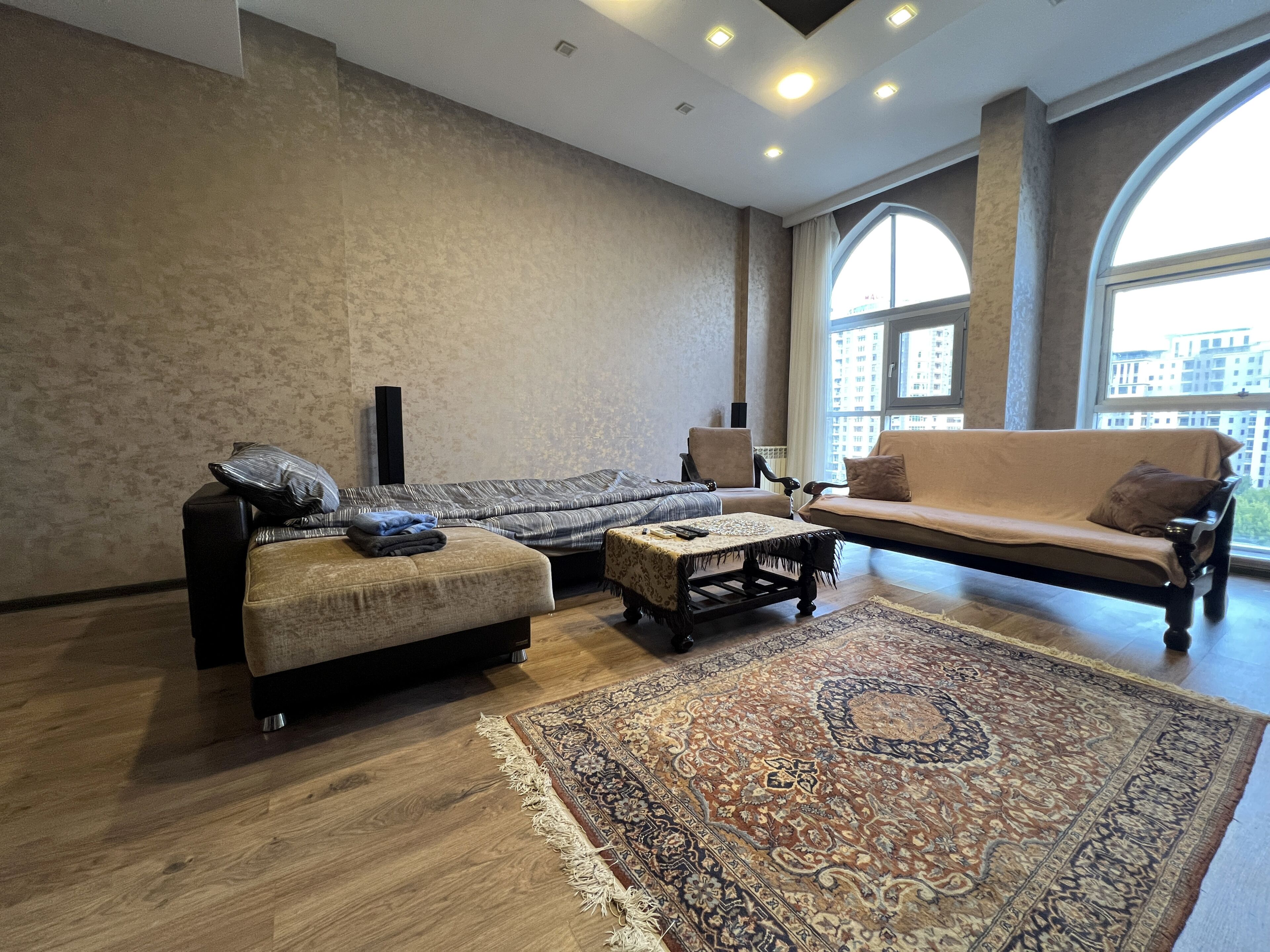 Ein geräumiges Wohnzimmer mit großem Teppich, Sofas und einem Couchtisch.