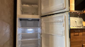 Ein offener Kühlschrank mit mehreren Regalen und einem Gefrierfach.
