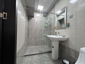 A modern bathroom with a glass-enclosed shower, a white sink, and a mirror. - Spacious 2BR near Winter Park - Sleeps 5 (Baku)
