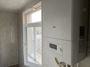 Una habitación con ventana, pared blanca y termostato.