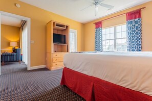 Una habitación de hotel con cama, televisión, escritorio y armario.