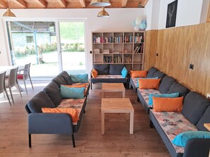 A modern living area with sofas, a coffee table, and a bookshelf.