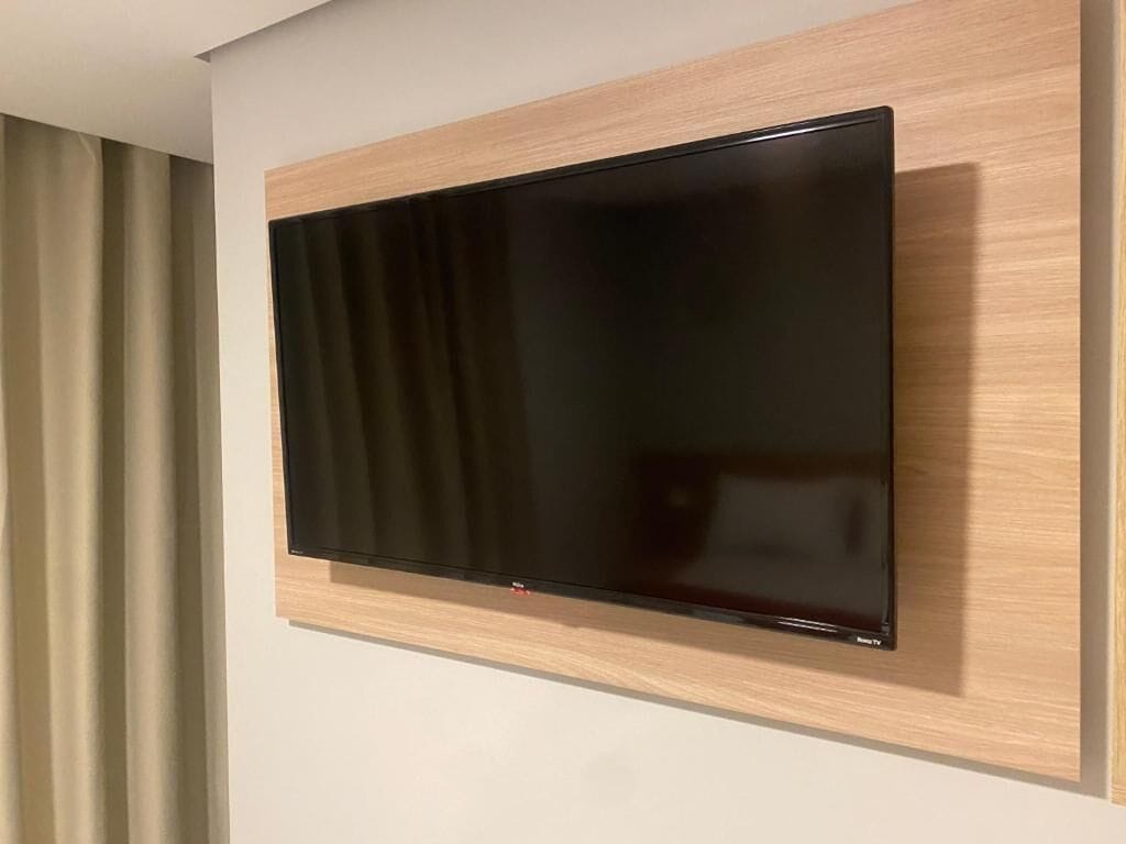 Televisor de pantalla plana montado en una pared con marco de madera.