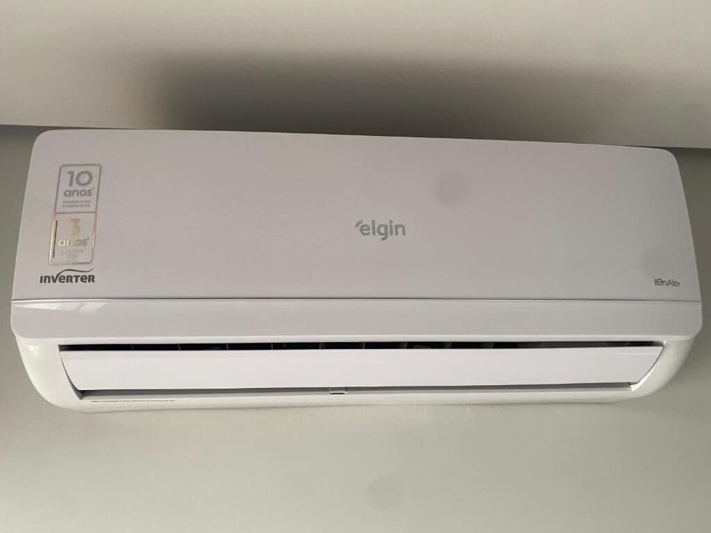 Eine weiße Klimaanlage mit den Aufschriften 'elgin' und 'Inverter', die an einem 10 Jahre alten Modell erkennbar ist.