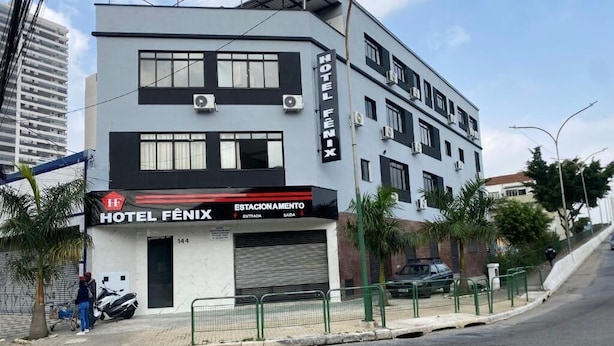 Un hotel moderno con estructura de dos pisos, una entrada visible y un estacionamiento.