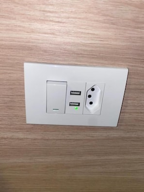 A wall-mounted electrical outlet with a USB port and a power socket.