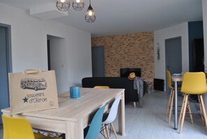 Ein moderner Essbereich mit Holztisch, Stühlen und einer Wand in Backsteinoptik.