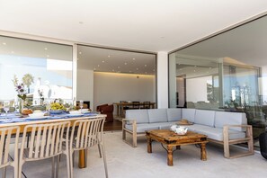 A modern living space with a dining area, a sofa, and a coffee table. - Villa 911 · Heated pool &Unique View in Praia da luz (Luz)