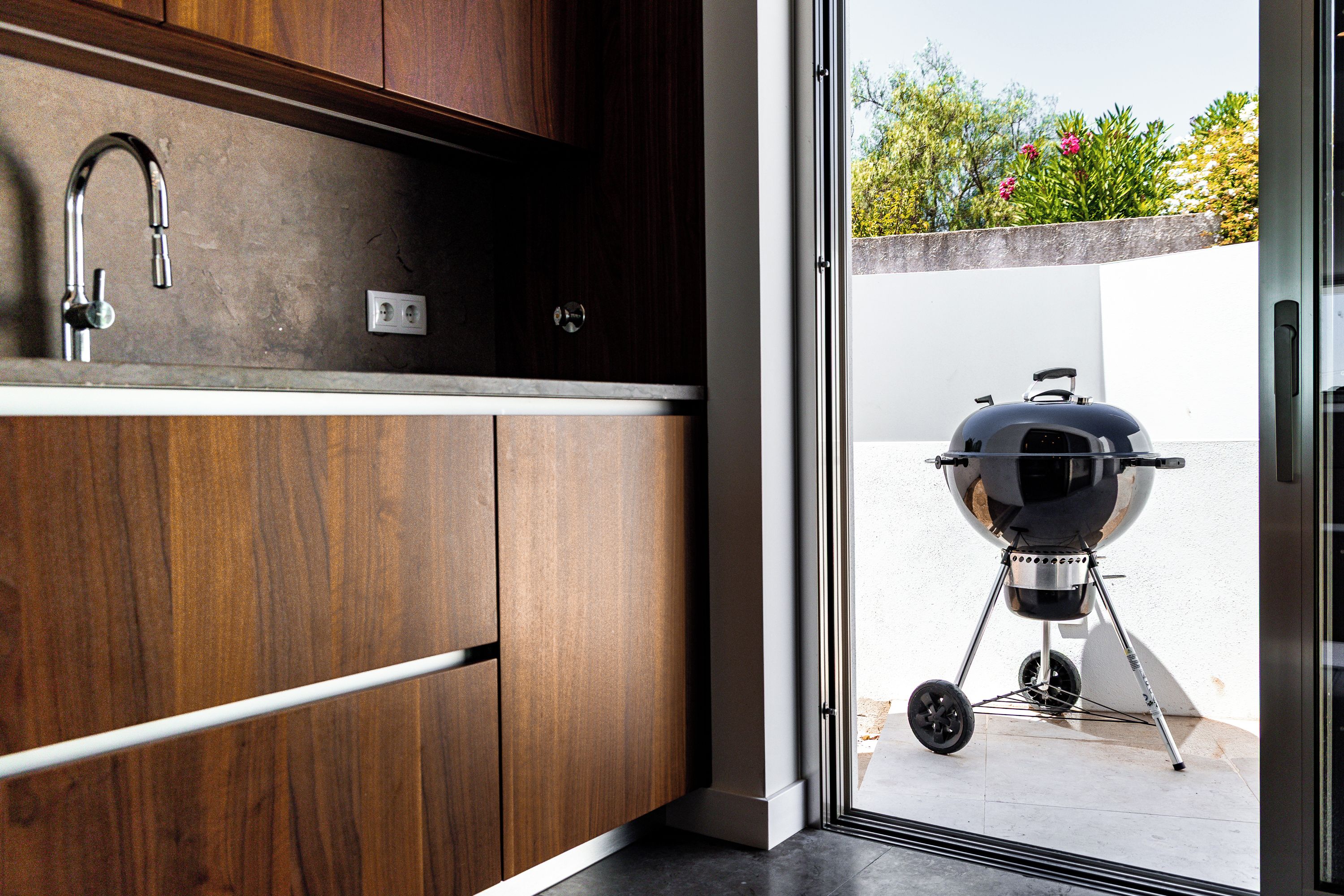 Una cocina moderna con armarios de madera y un lavamanos de acero inoxidable.