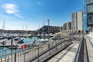 A marina with boats docked, a pedestrian walkway, and modern buildings in the background. - Smart and Stylish Twin Bed Studio (Southampton)