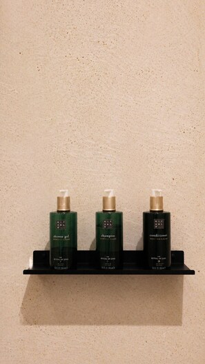 Tres botellas de productos Ritual de Jing sobre una estantería.