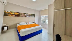 Ein Schlafzimmer mit Bett, Nachttisch, Kleiderschrank und einem großen Fenster.