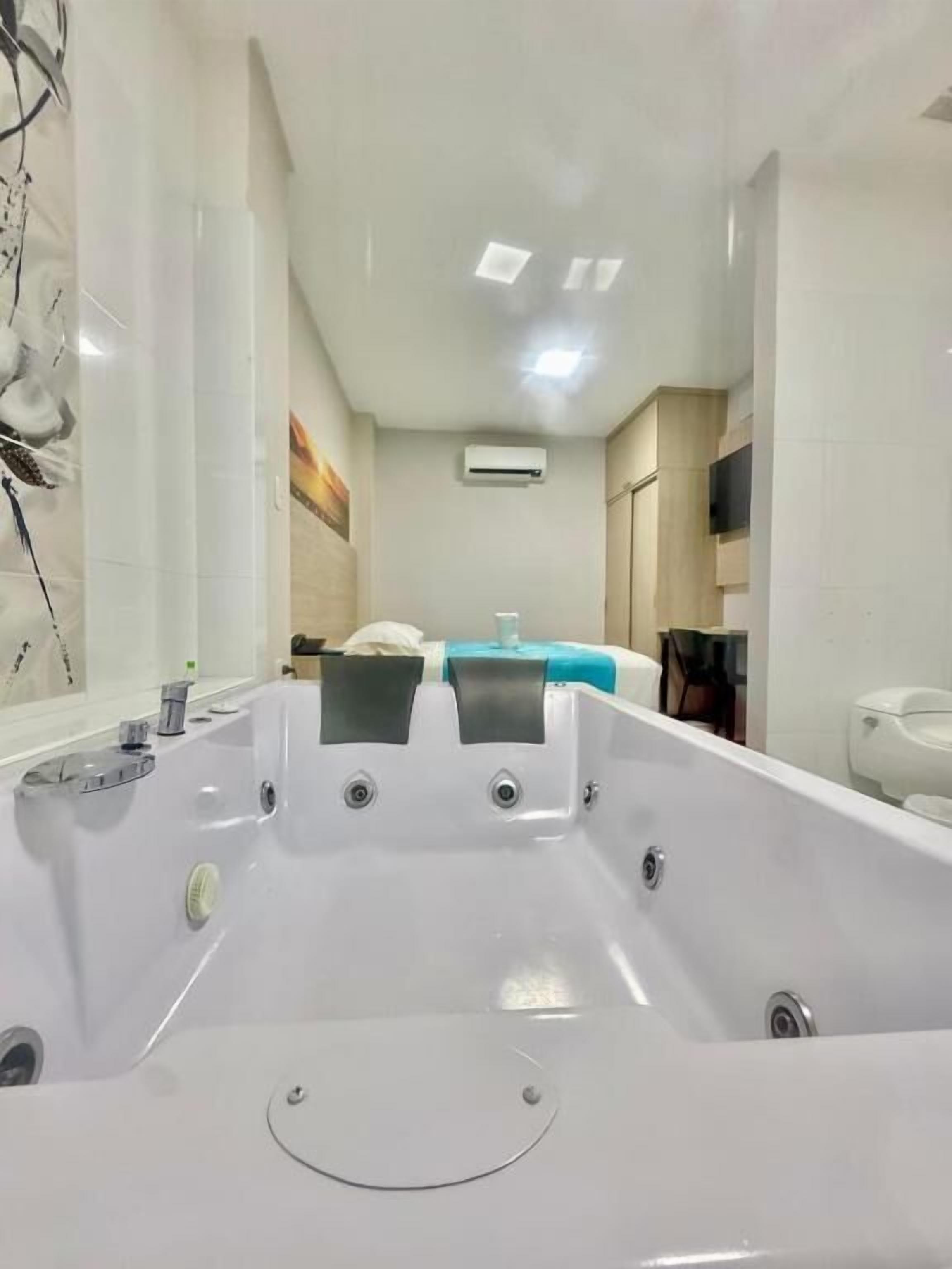 Ein modernes Badezimmer mit einer großen Badewanne, einer Toilette und einer Duschkabine.