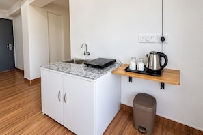 A compact kitchenette with a built-in stove, a sink, and a small countertop.