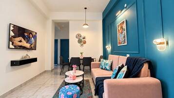 Una sala de estar moderna con un sofá, una mesa de centro y un televisor montado en la pared.