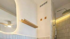 Ein modernes Badezimmer mit Waschbecken, Toilette und Duschbereich in Weiß.