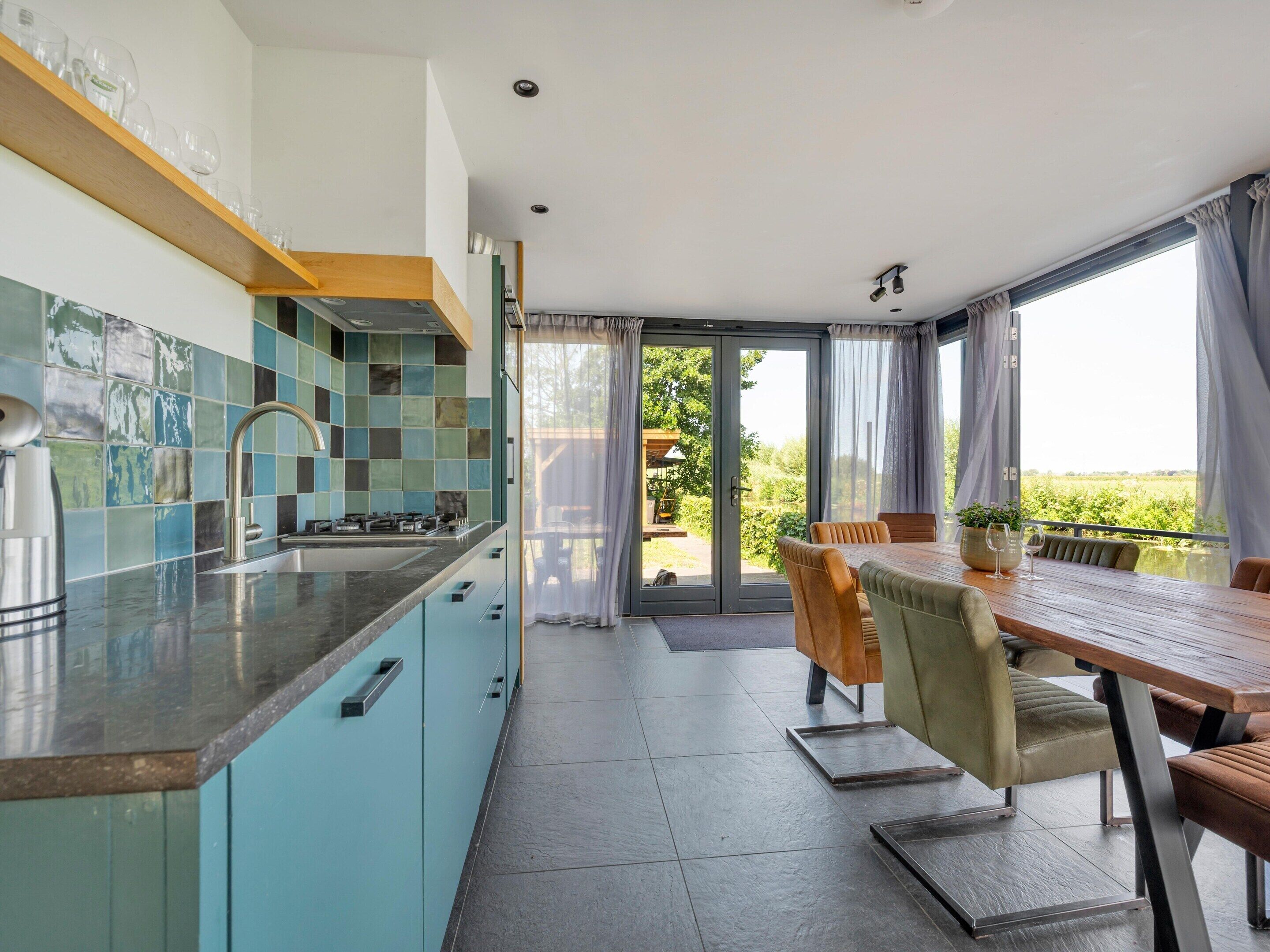 A modern kitchen with a built-in stove and a dining area with a table and chairs.