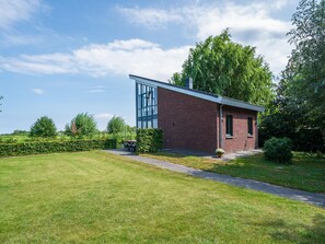 A modern building with a glass facade, surrounded by a well-maintained lawn and mature trees. - Waterfront Villa With Picturesque Views (Hekendorp)