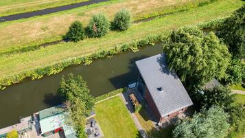Luchtbeeld van een bezit met een rivier, een aanlegsteiger en een gebouw met schuin dak.