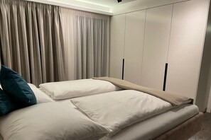 Ein Schlafzimmer mit Bett, Vorhängen und Einbauschränken.