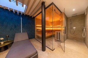 A modern bathroom with a glass shower enclosure, a bench, and a massage chair. - Penthouse with a dream view (Bramberg am Wildkogel)