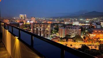 A nighttime cityscape with buildings and a body of water.
