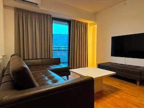 Una sala de estar moderna con un sofá, una mesa de centro y un televisor de pantalla plana.